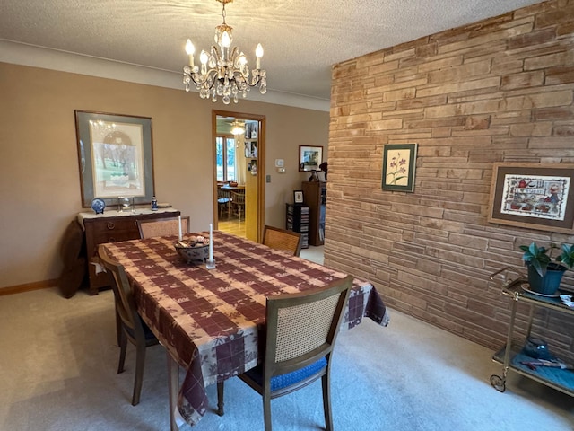 dining area featuring a notable chandelier, a textured ceiling, and light carpet