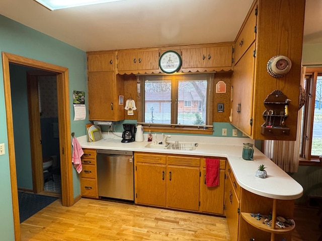 kitchen featuring dishwasher, a healthy amount of sunlight, light wood-type flooring, and sink