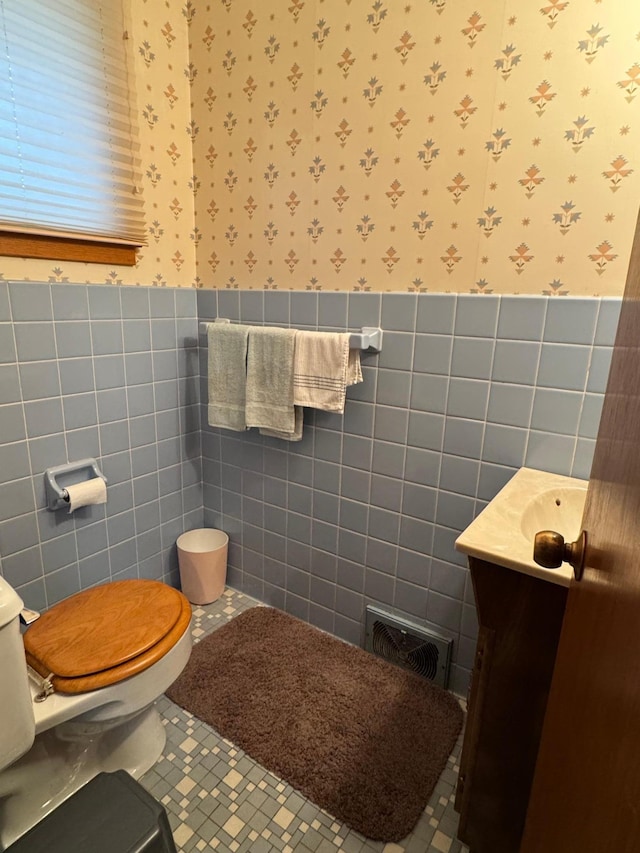 bathroom featuring tile patterned flooring, vanity, tile walls, and toilet