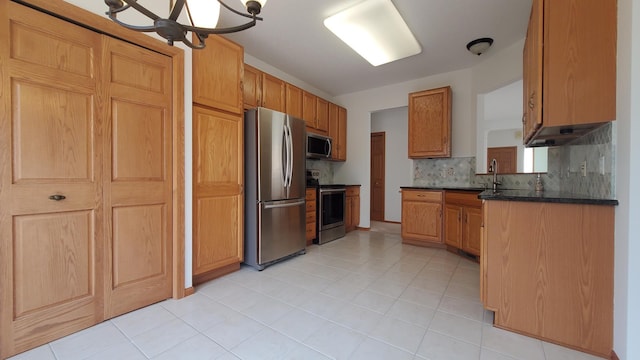 kitchen featuring light tile patterned floors, an inviting chandelier, a sink, stainless steel appliances, and tasteful backsplash