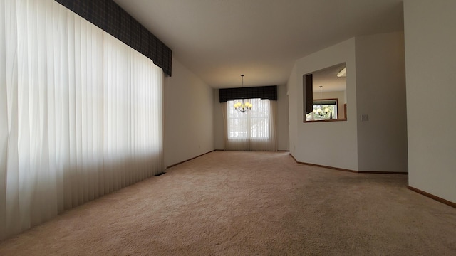 empty room with baseboards, carpet floors, and a chandelier