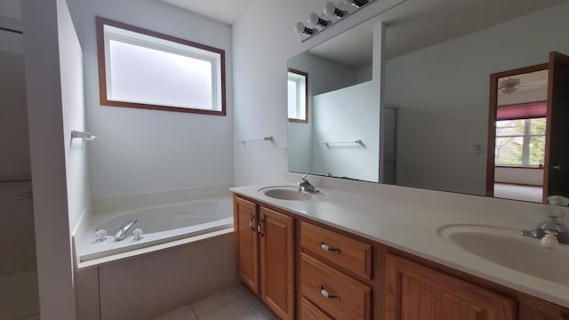 full bathroom featuring a sink, a garden tub, double vanity, and tile patterned floors