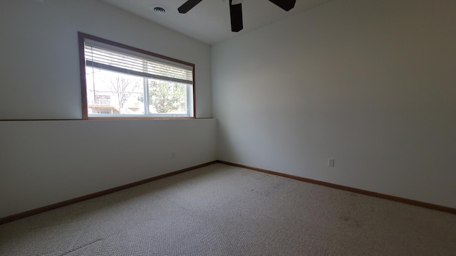 empty room with visible vents, light carpet, baseboards, and a ceiling fan