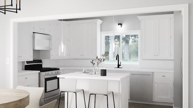 kitchen with gas stove, white cabinets, and an island with sink