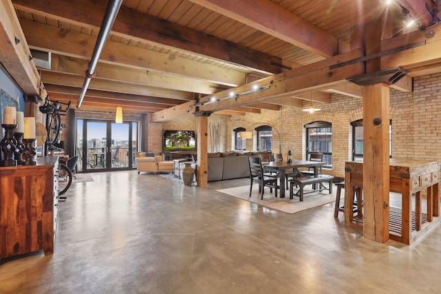 dining space featuring beam ceiling, concrete floors, wood ceiling, and brick wall