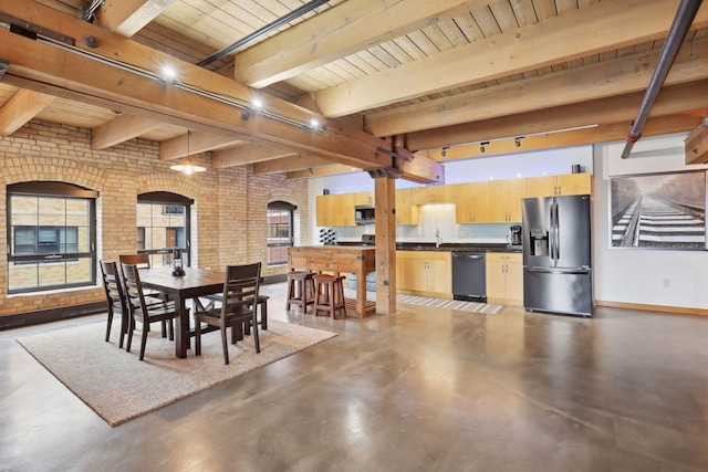 dining room featuring beam ceiling, sink, brick wall, concrete floors, and wood ceiling