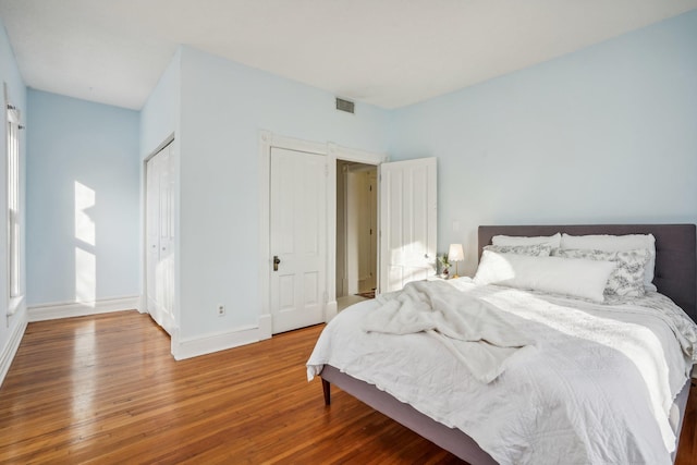 bedroom featuring wood-type flooring and multiple windows