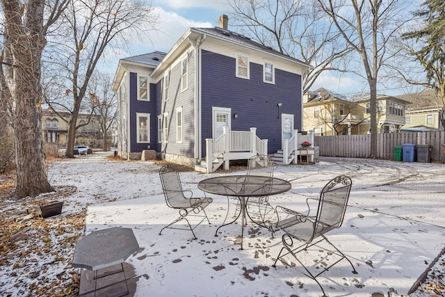 view of snow covered back of property