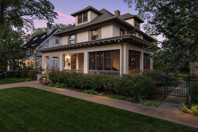 view of front of home featuring covered porch, fence, a yard, stucco siding, and a chimney