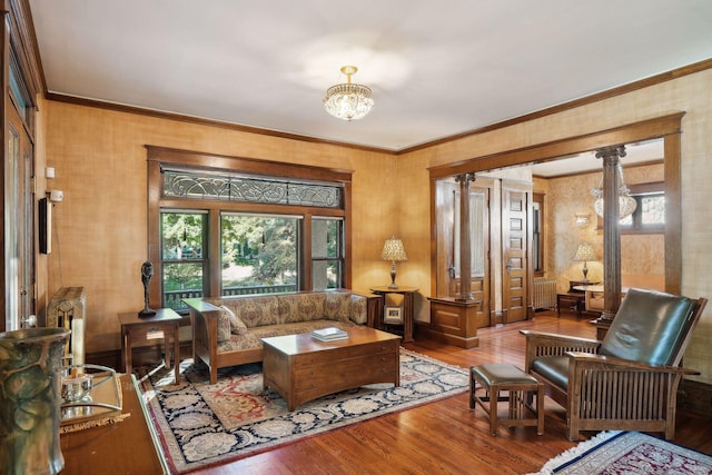 living room featuring a healthy amount of sunlight, crown molding, and wood finished floors