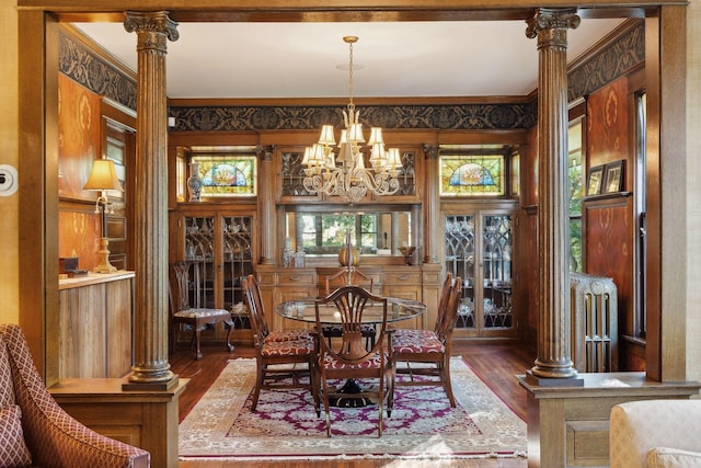 dining area featuring crown molding, decorative columns, radiator heating unit, and wood finished floors