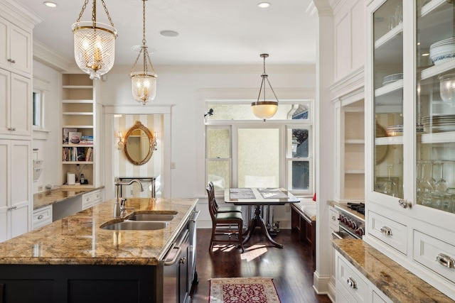 kitchen featuring decorative light fixtures, ornamental molding, dark wood-type flooring, white cabinetry, and a sink