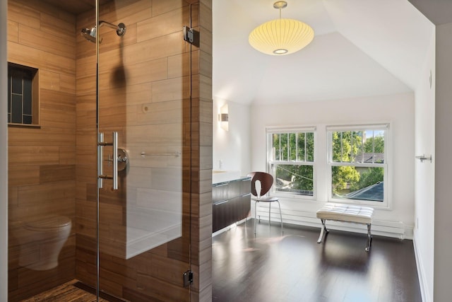 full bath featuring lofted ceiling, wood finished floors, a shower stall, and toilet