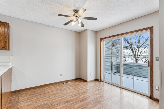 interior space with ceiling fan, a textured ceiling, and light hardwood / wood-style flooring