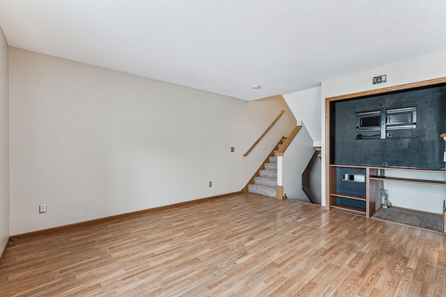 unfurnished living room featuring a textured ceiling and wood-type flooring