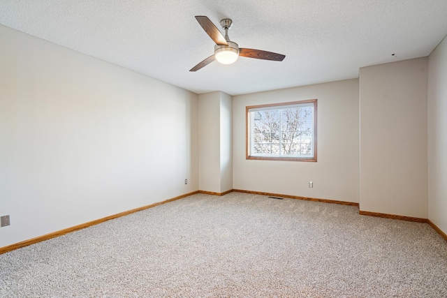 empty room with ceiling fan, a textured ceiling, and carpet flooring