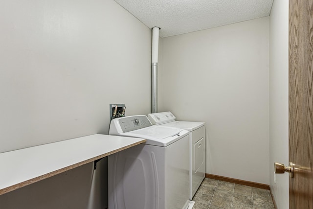 laundry area with washer and clothes dryer and a textured ceiling