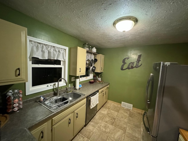 1630 3rd St N, Fargo, ND 58102 - kitchen with freestanding refrigerator, dishwashing machine, a textured ceiling, dark countertops, and light tile patterned flooring
