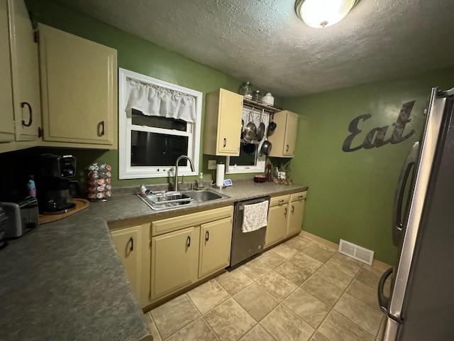 1630 3rd St N, Fargo, ND 58102 - kitchen with stainless steel appliances, a textured ceiling, light tile patterned flooring, and dark countertops