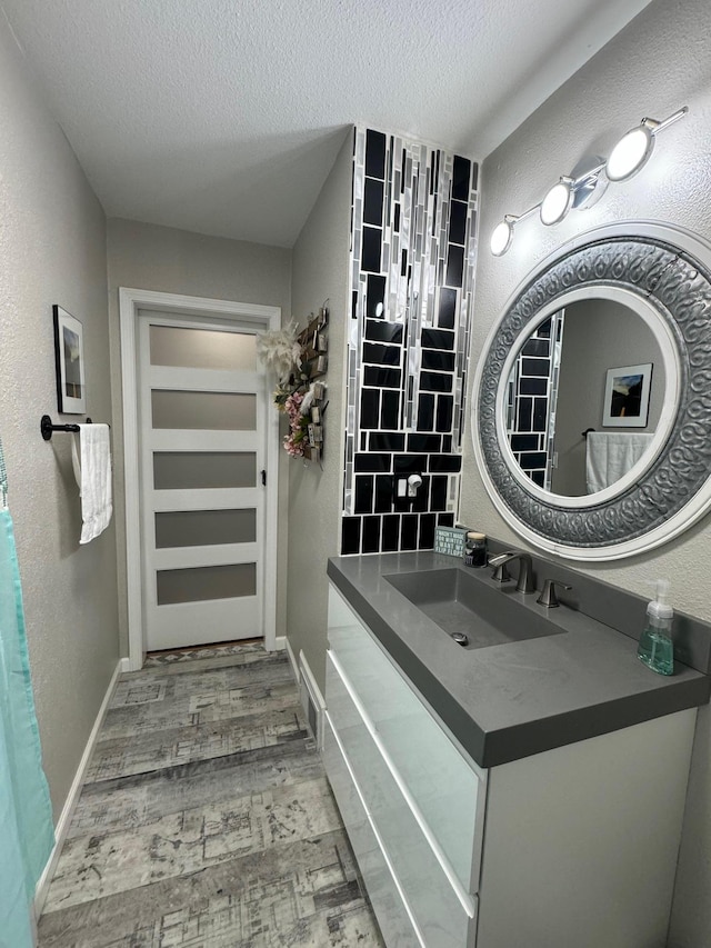1630 3rd St N, Fargo, ND 58102 - bathroom with a textured ceiling, wood finished floors, vanity, and a textured wall
