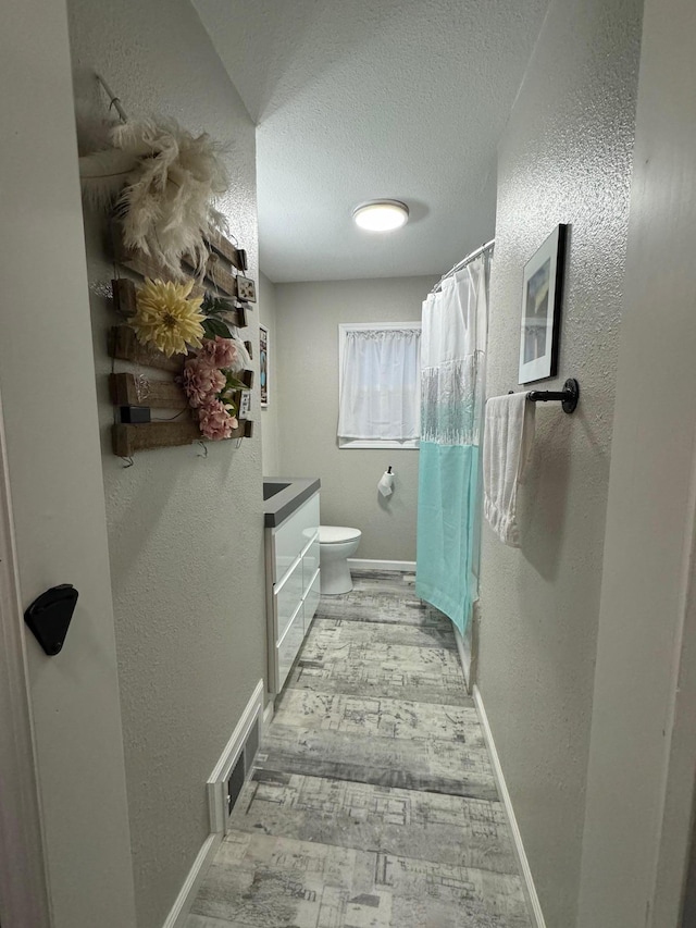1630 3rd St N, Fargo, ND 58102 - bathroom with a textured ceiling, wood finished floors, vanity, a textured wall, and a shower with curtain