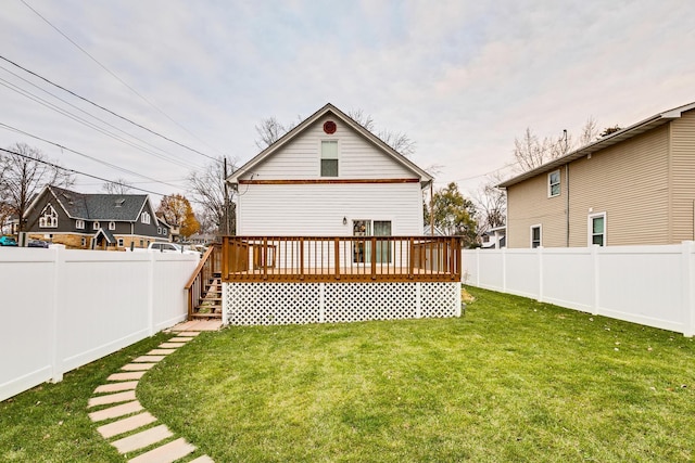 back of property with a lawn and a wooden deck