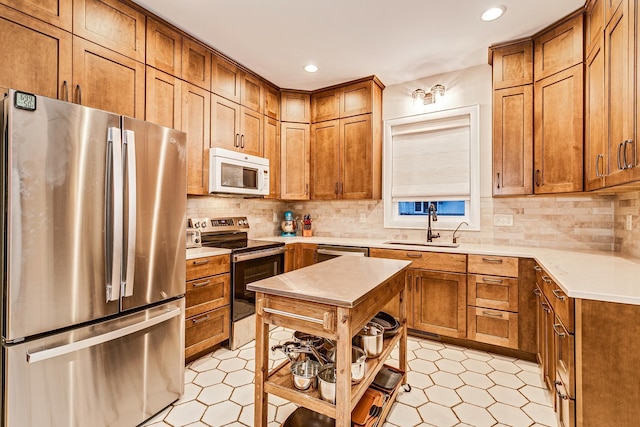 kitchen with backsplash, sink, and appliances with stainless steel finishes