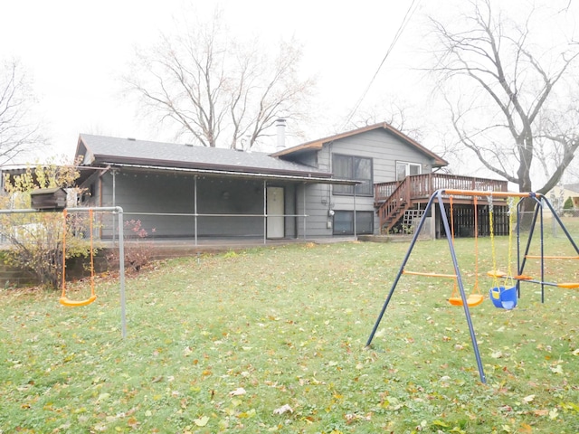 rear view of property featuring a sunroom, a playground, a yard, and a wooden deck