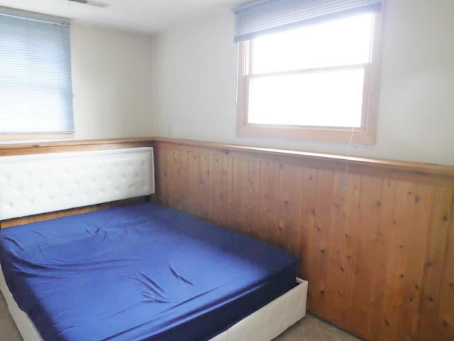 unfurnished bedroom featuring wooden walls