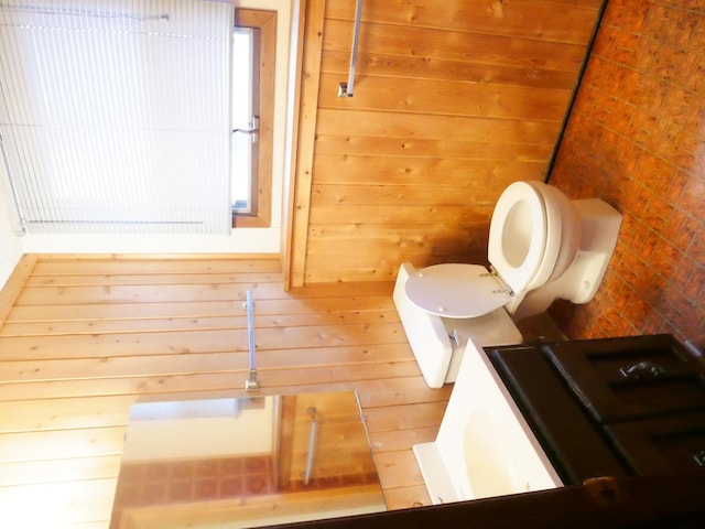 bathroom featuring toilet and wooden walls