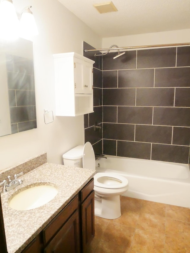 full bathroom featuring vanity, tiled shower / bath combo, and toilet