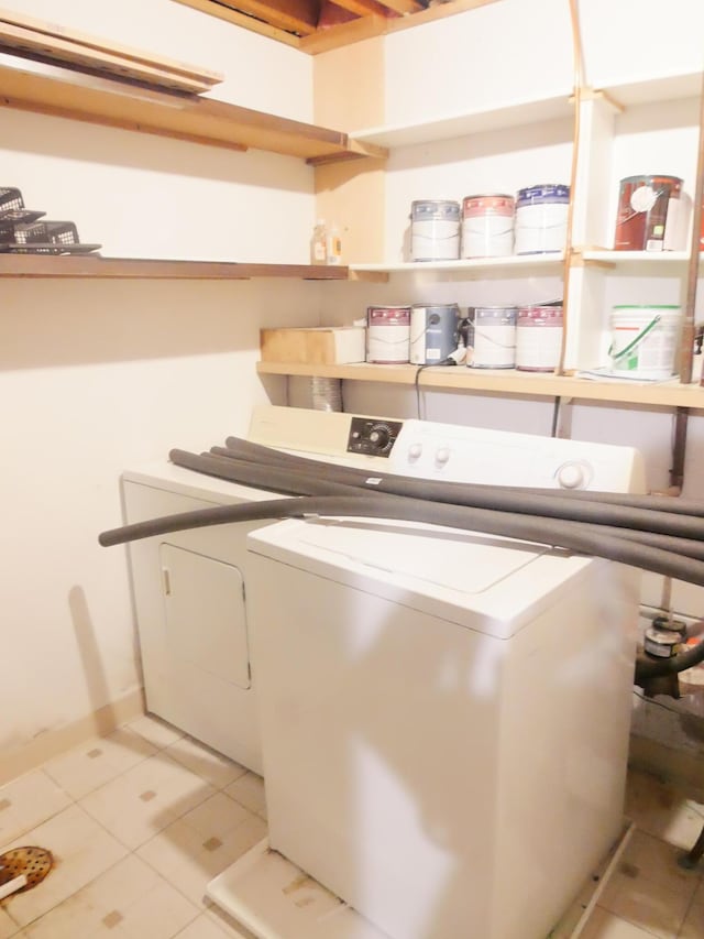 laundry room with light tile patterned floors and washing machine and dryer