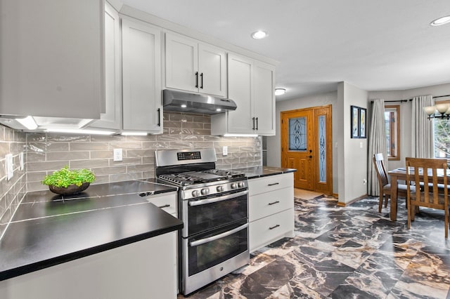 kitchen with white cabinetry, double oven range, and backsplash