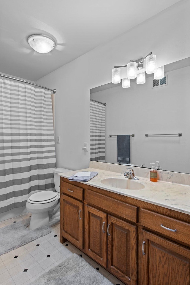 bathroom featuring vanity, toilet, and tile patterned flooring