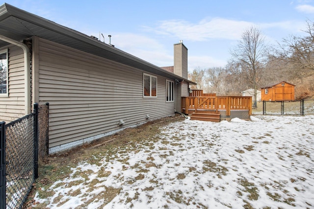 yard covered in snow featuring a deck