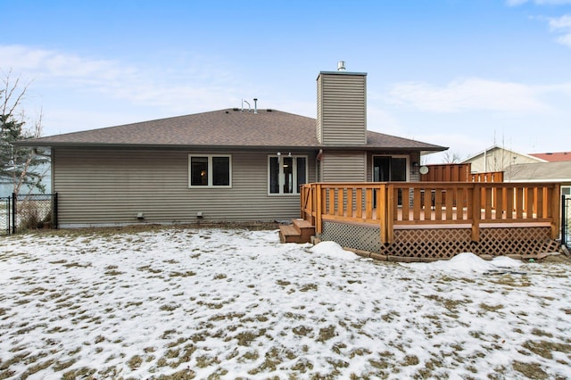 snow covered rear of property with a wooden deck