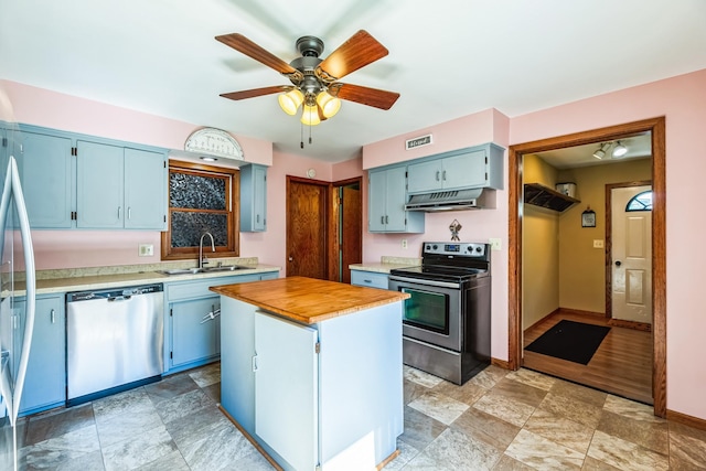 kitchen featuring under cabinet range hood, blue cabinets, a sink, visible vents, and appliances with stainless steel finishes