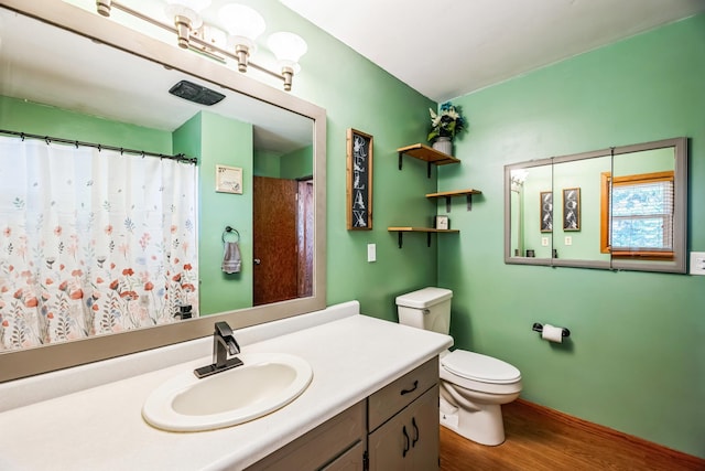 bathroom with vanity, a shower with shower curtain, wood finished floors, and toilet