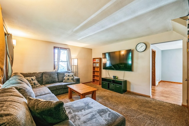 living room with carpet flooring, a textured ceiling, and baseboards