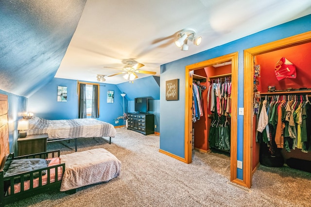 carpeted bedroom with lofted ceiling, a spacious closet, a textured ceiling, and baseboards