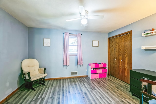 playroom with a ceiling fan, wood finished floors, visible vents, and baseboards