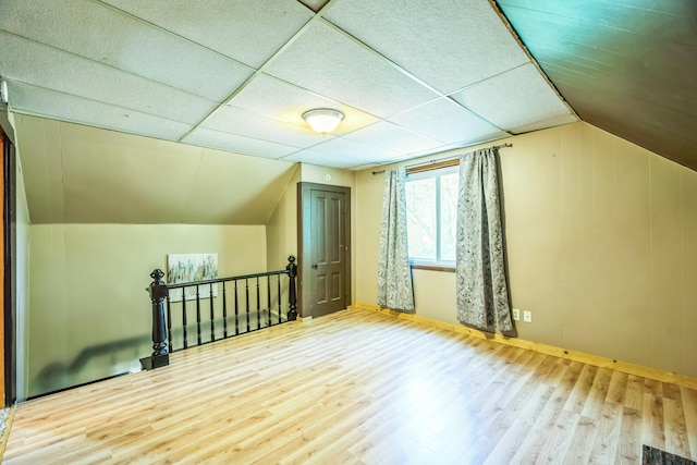 bonus room featuring vaulted ceiling, baseboards, and wood finished floors