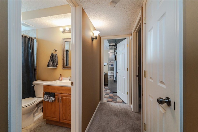 bathroom featuring vanity, a textured ceiling, toilet, and walk in shower