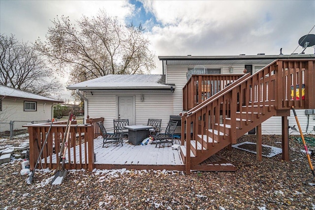 snow covered back of property featuring a deck