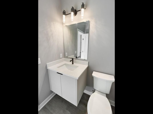 bathroom featuring hardwood / wood-style flooring, vanity, and toilet