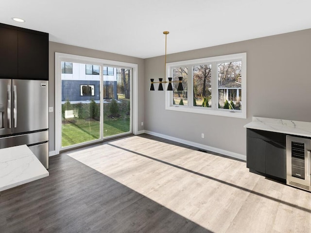 unfurnished dining area with hardwood / wood-style flooring and beverage cooler