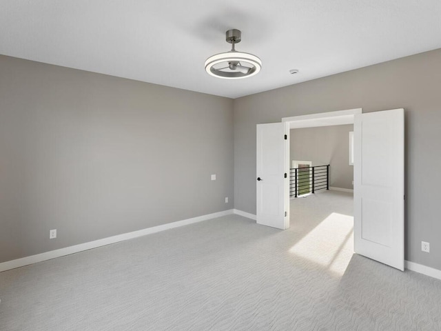 unfurnished room featuring light carpet