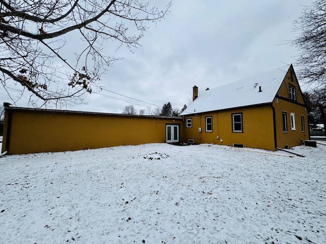 view of snow covered rear of property