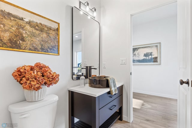 bathroom featuring vanity, hardwood / wood-style floors, and toilet