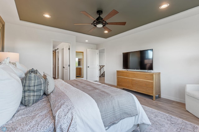 bedroom featuring a tray ceiling, ceiling fan, and light hardwood / wood-style floors